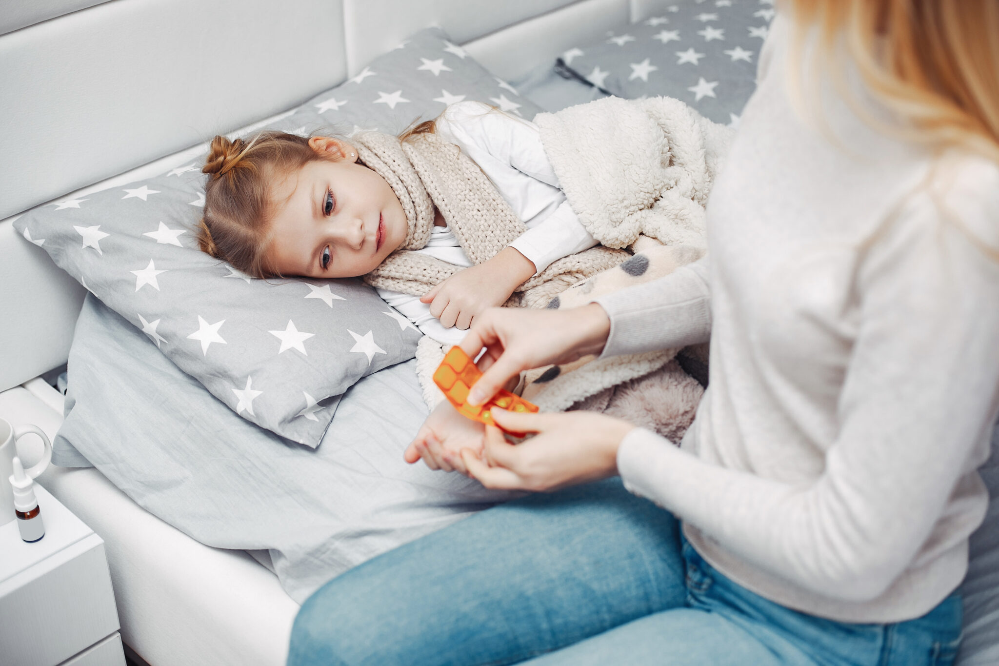 Illnes little girl. Mother with daughter. Child lying in a bed