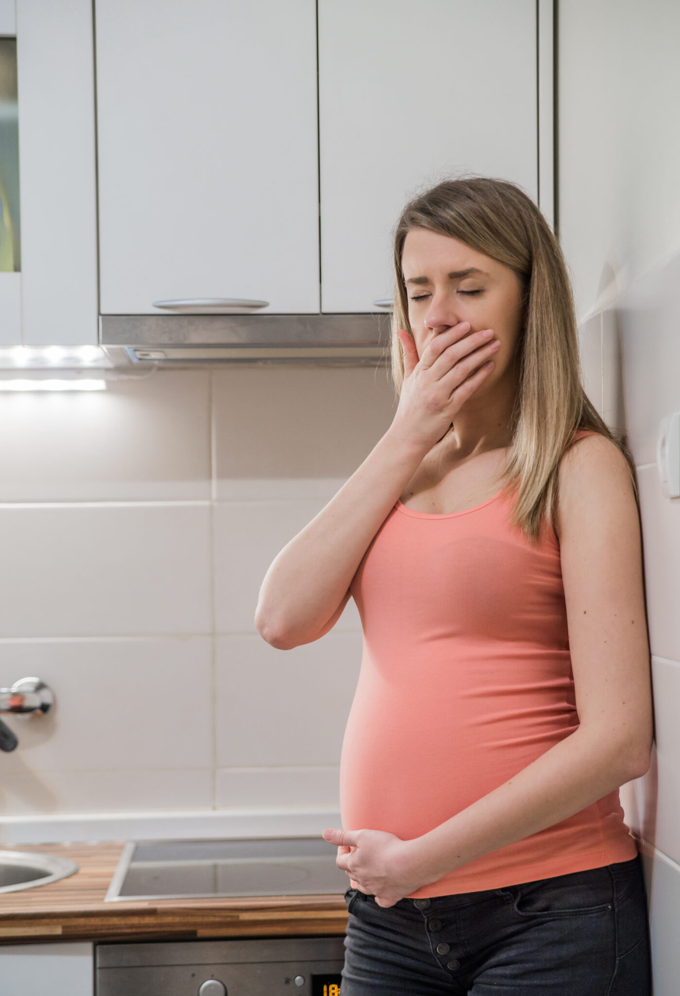 Pregnant woman with vomiting. Upset pregnant woman with hand on forehead