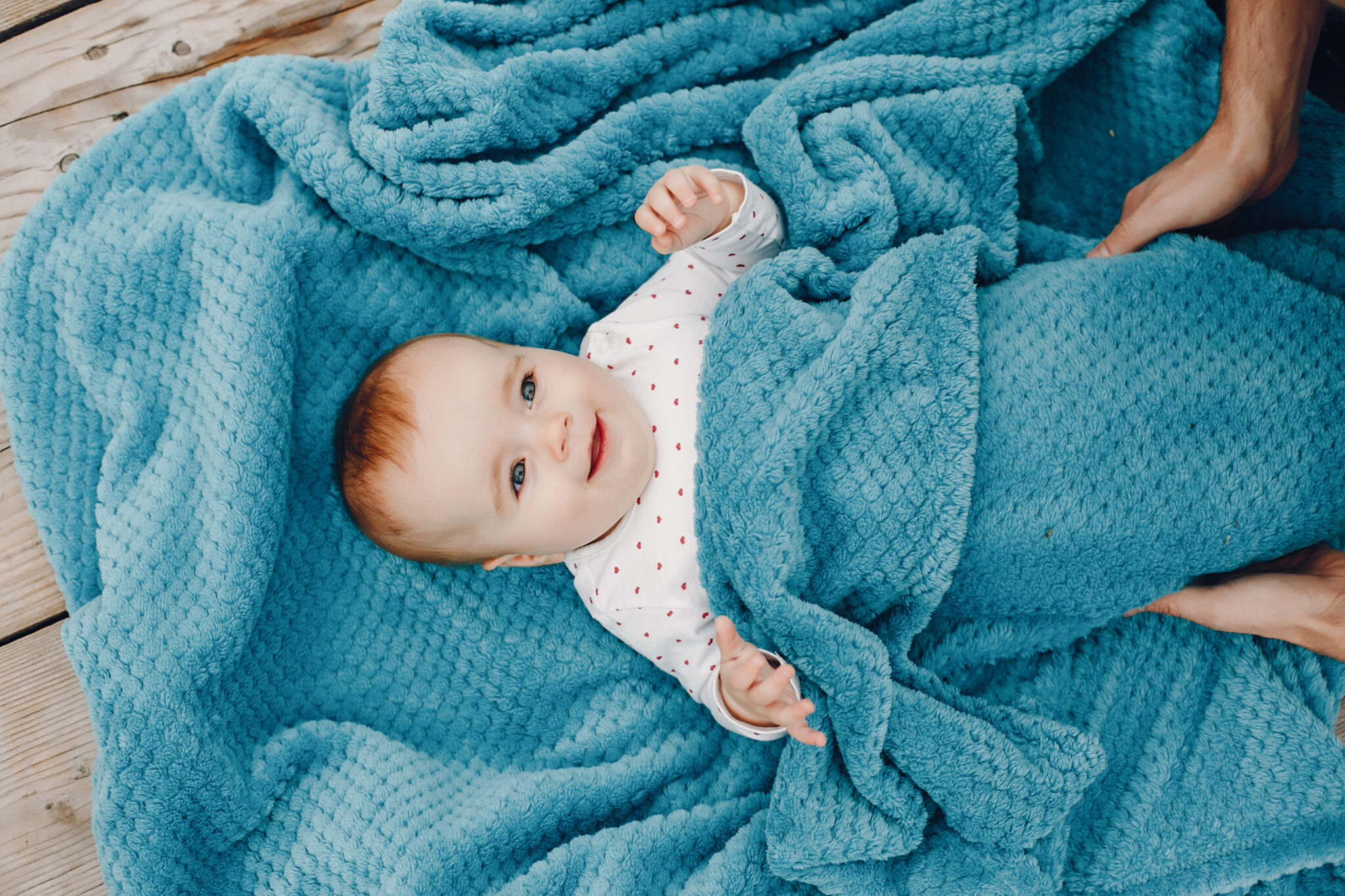 Little girl lying on a blue plaid. Child in a summer park